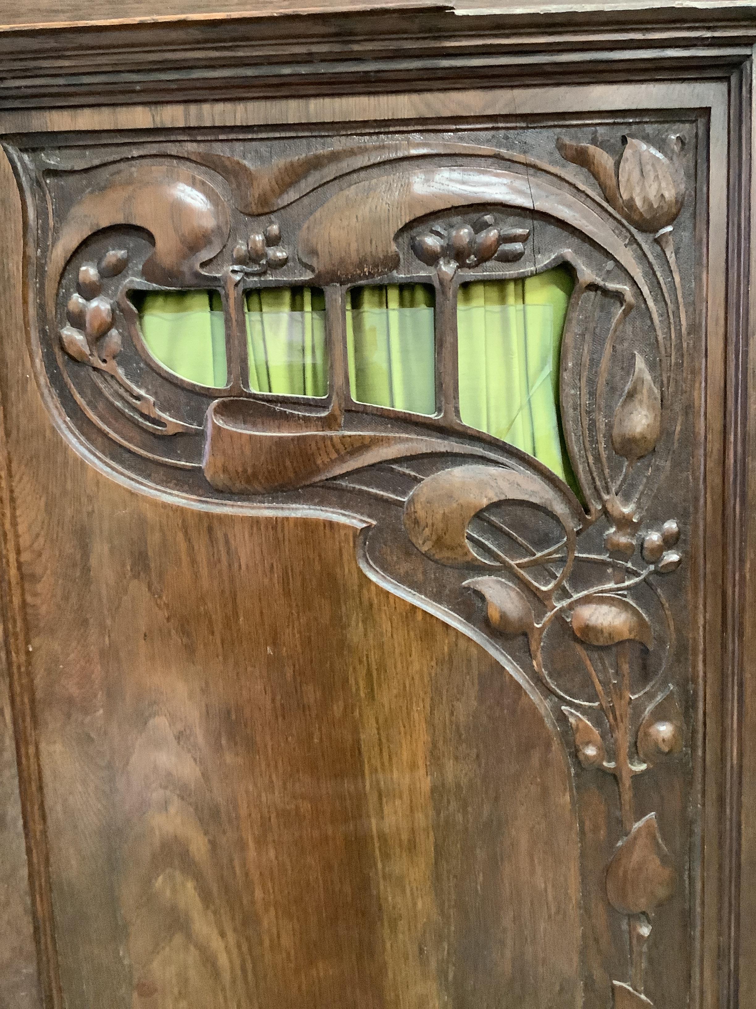 A late 19th century French Art Nouveau carved oak compactum wardrobe, width 205cm, depth 64cm, height 218cm